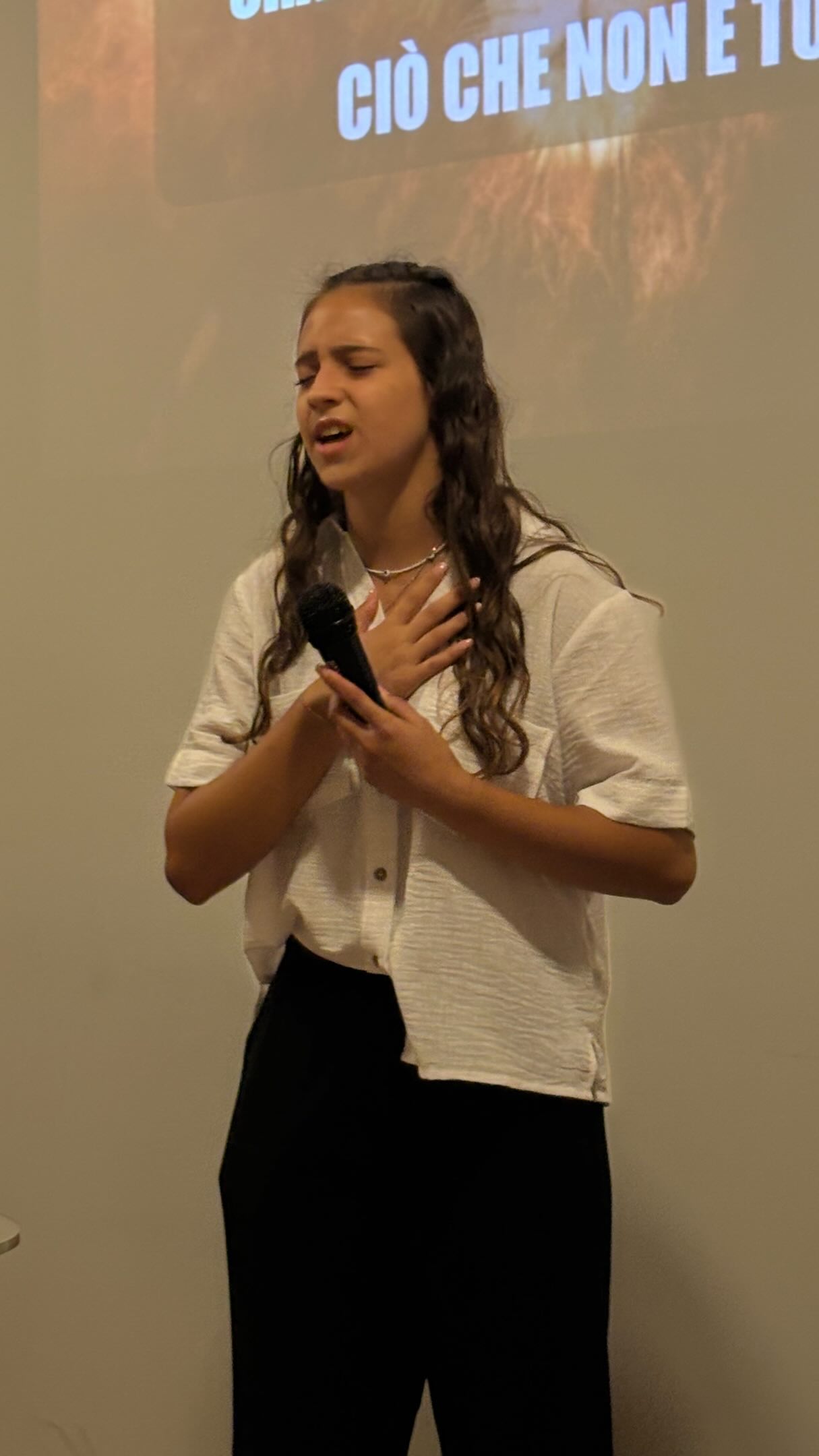 Una giovane durante un momento di canto della comunità